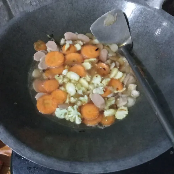 Masukkan wortel, kembang kol, dan jagung putren. Kemudian tuang air, lalu biarkan mendidih dan sayuran setengah matang.
