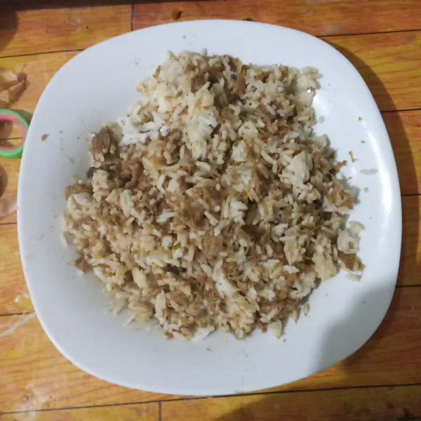 Campurkan nasi putih dengan daging rendang, lalu aduk rata.