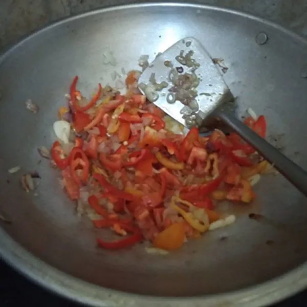 Masukkan tomat dan cabai, lalu aduk hingga layu.