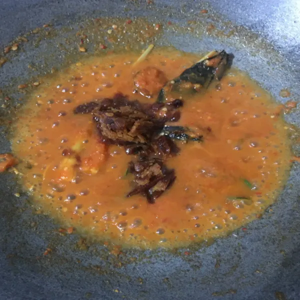 Tumis bumbu halus dengan sedikit minyak, tambahkan daun jeruk, daun salam, serai, dan lengkuas. Masak hingga bumbu matang, kemudian masukkan gula merah, lalu aduk rata.