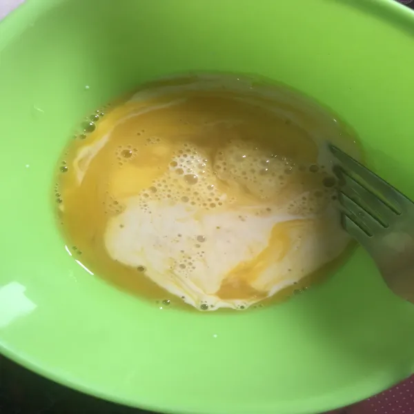 Pecahkan telur dan tambahkan susu cair. Kocok hingga tercampur rata.