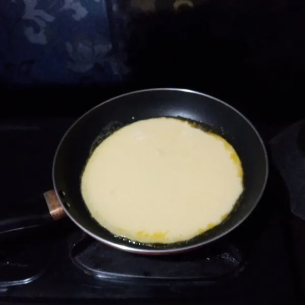 Panaskan wajan dengan api sangat kecil, olesi dengan margarin/ mentega/ butter di atasnya. Lalu tuang adonan dan ratakan.