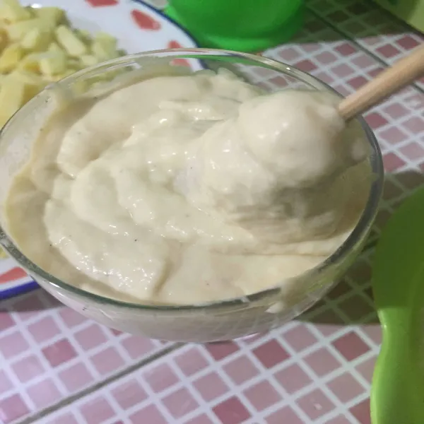 Setelah 10 menit, keluarkan adonan, lalu masukkan ke dalam gelas. Celupkan sosis moza ke dalam adonan sampai menutupi seluruh permukaannya.
