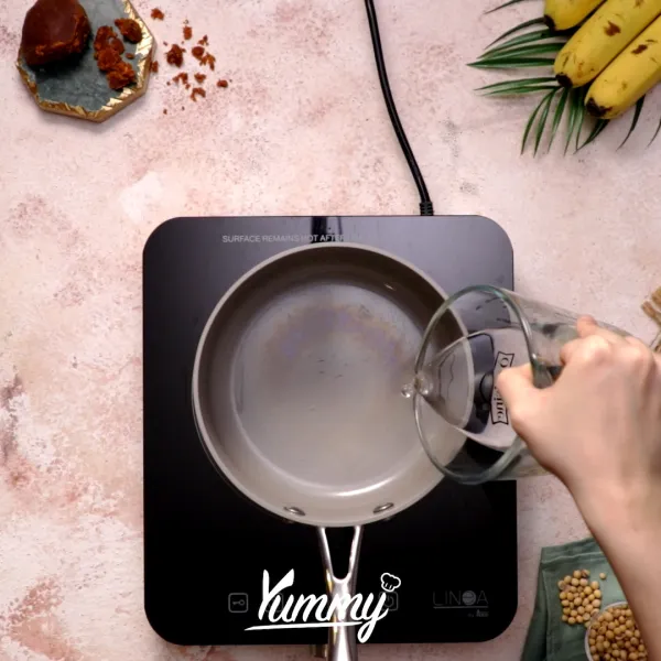 Buat saus gula dengan mencampurkan air, gula kelapa, dan daun pandan ke dalam panci. Masak hingga seluruh gula larut dan mengental. Sisihkan.