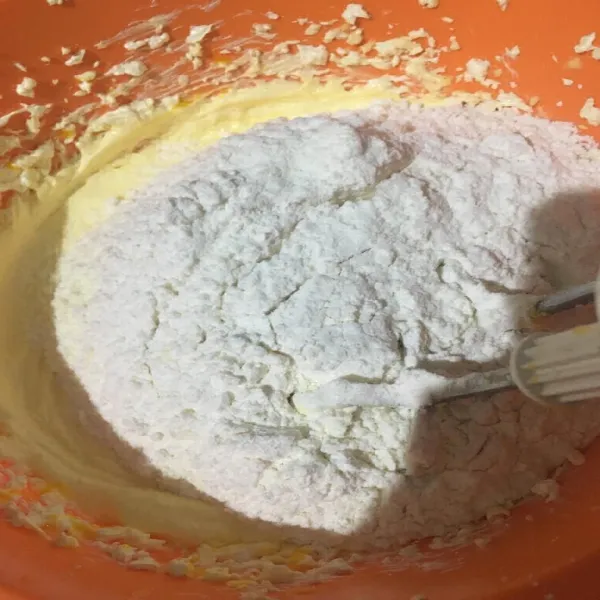 Kemudian masukkan tepung terigu dan susu bubuk sambil diayak, aduk hingga tercampur merata.