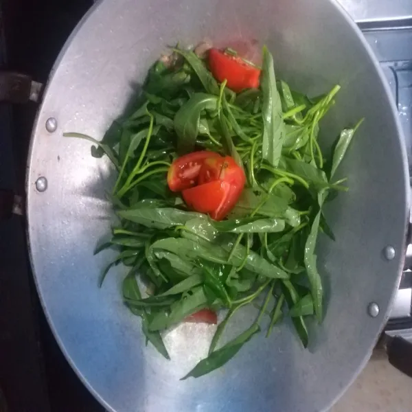 Masukkan batang kangkung terlebih dahulu, setelah agak layu masukkan daun kangkung dan tomat.