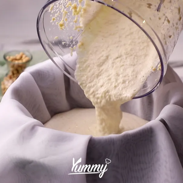Siapkan kain penyaring di atas panci. Tuangkan sari kedelai, lalu tekan dan keluarkan susu kedelai sebanyak mungkin.