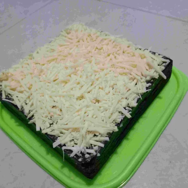 Jika cake sudah dingin bagian atas oles dengan margarin kemudian parut keju hingga menutupi bagian atasnya cake telah selesai untuk dihidangkan