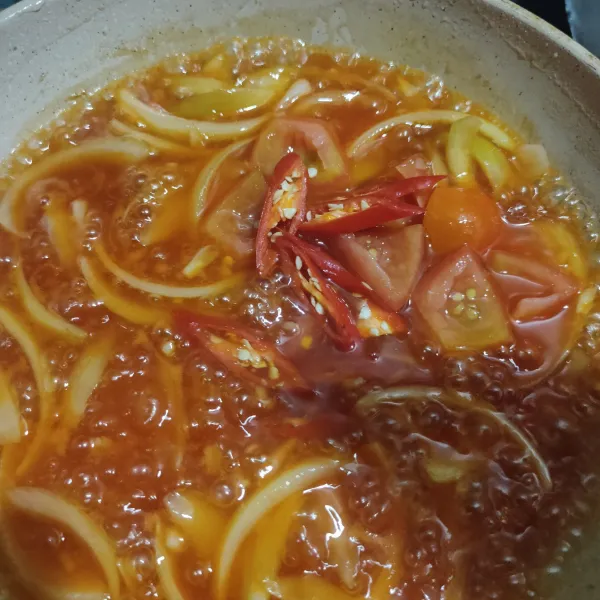 Masukkan potongan tomat dan cabai merah, lalu aduk rata. Masak hingga mendidih, lalu angkat dan sajikan.