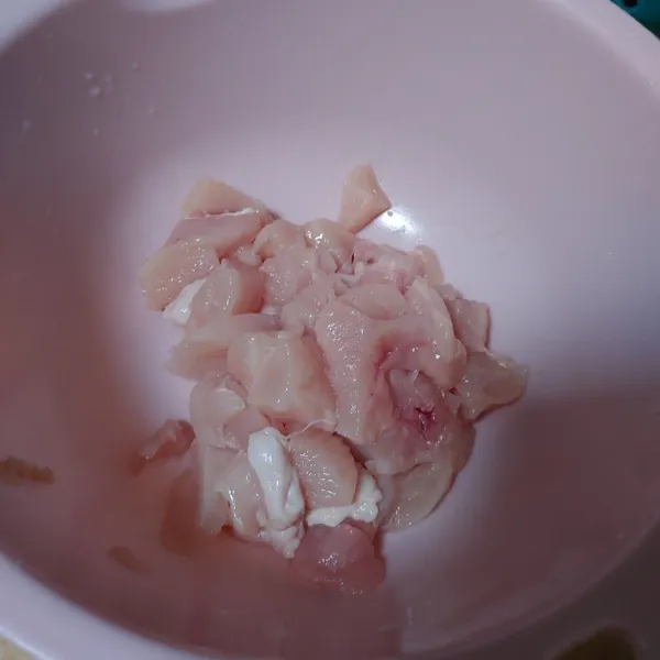 Cuci bersih daging ayam dan potong dadu.