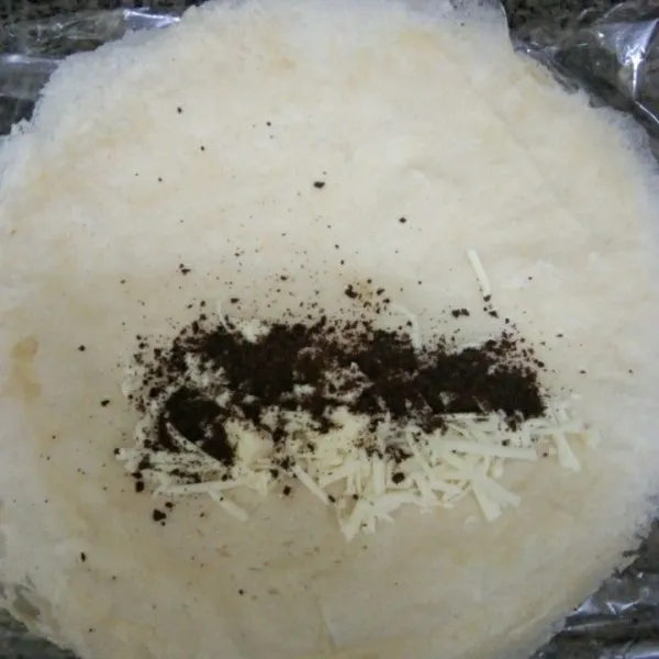 Siapkan kulit lumpia, beri keju parut dan bubuk oreo di bagian sisi gulung dan rekatkan dengan tepung terigu yang telah dicampur air.