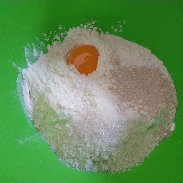 Campur tepung terigu, kuning telur, ragi instan, susu bubuk dan gula pasir lalu aduk rata. Lalu tambahkan air, uleni hingga kalis.