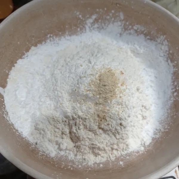 Masukkan tepung tapioka, tepung terigu, garam dan kaldu bubuk ke dalam mangkok.