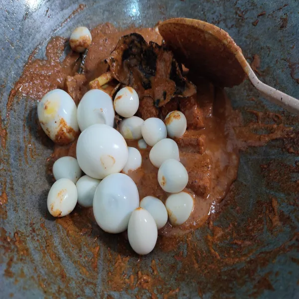 Lalu masukkan lagi telur rebus, aduk rata dan kecilkan api. Tambahkan ambu-ambu kelapa, aduk rata.