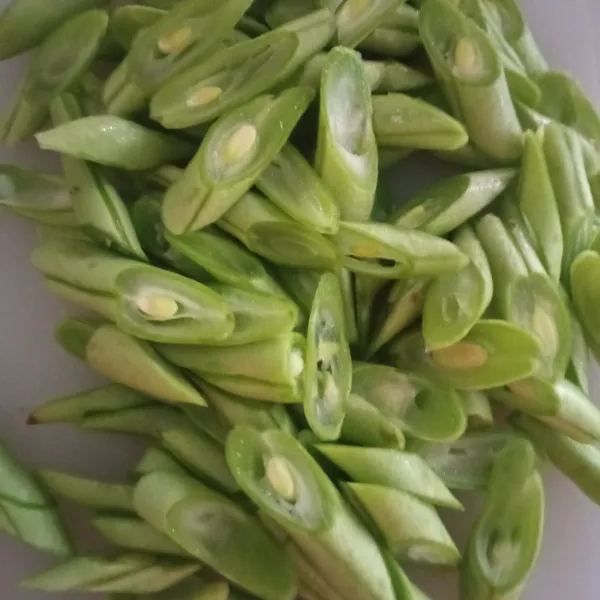 Buang ujung-ujungnya buncis, lalu iris menyerong.