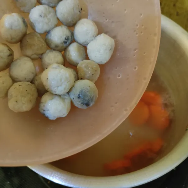 Masukkan bola-bola ikan, kaldu bubuk, garam, gula pasir, dan lada bubuk. Masak hingga wortel dan bola-bola ikan matang.
