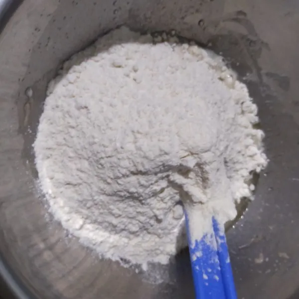 Lalu masukkan tepung terigu dan garam, aduk rata.