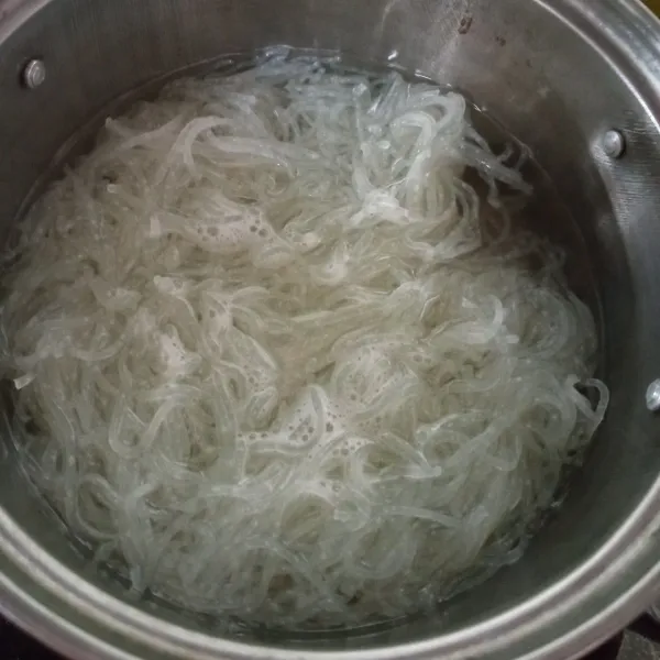 Rebus bihun hingga terurai dan matang, lalu angkat dan tiriskan.