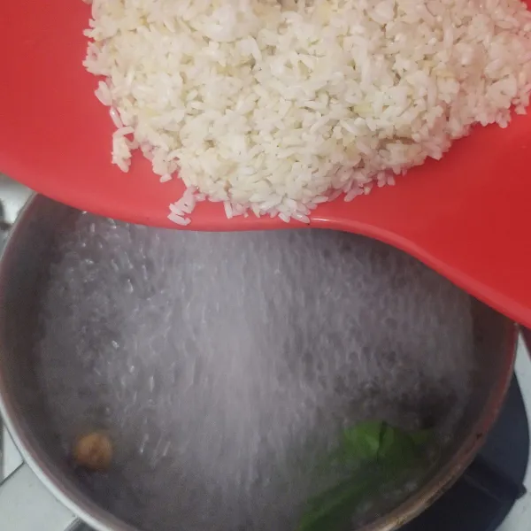 masak air bersama bumbu perebus beras, tambahkan 1/2 sdm minyak bekas penggoreng bawang, setelah mendidih, masukkan beras, rebus hingga 1/3 matang, matikan api kompor