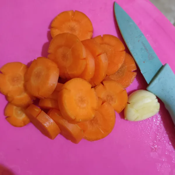 Potong-potong wortel dan geprek bawang putih.