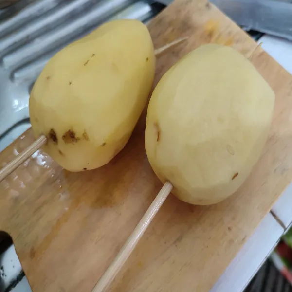 Tusuk kentang dengan tusuk sate secara perlahan agar tidak patah.