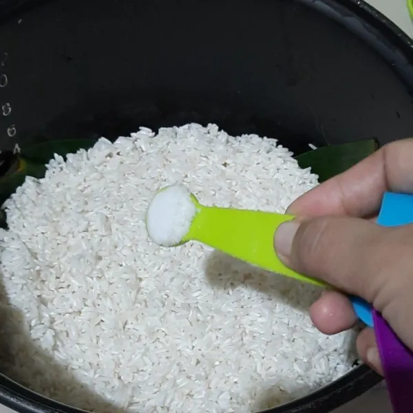 Campurkan garam ke dalam beras yang sudah dicuci.