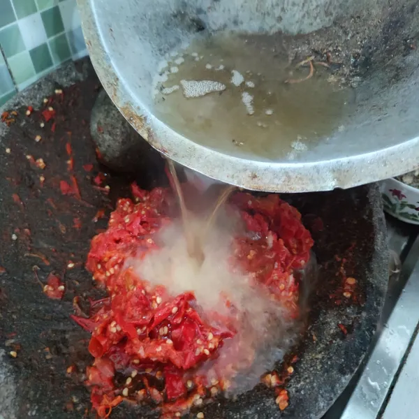 Lalu siram minyak panas bekas menggoreng ikan bada ke atas cabai yang sudah di ulek. Aduk cepat dan koreksi rasa.