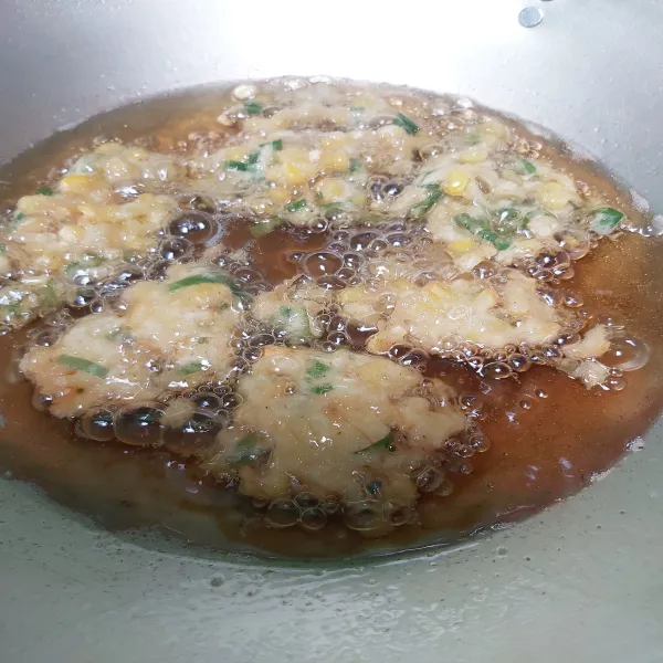 Goreng bakwan jagung hingga kedua sisinya kering berwarna kuning kecoklatan lalu angkat dan tiriskan lakukan hingga selesai.