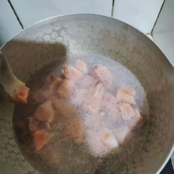 Celupkan ikan salmon di air hangat sebentar saja supaya matang.