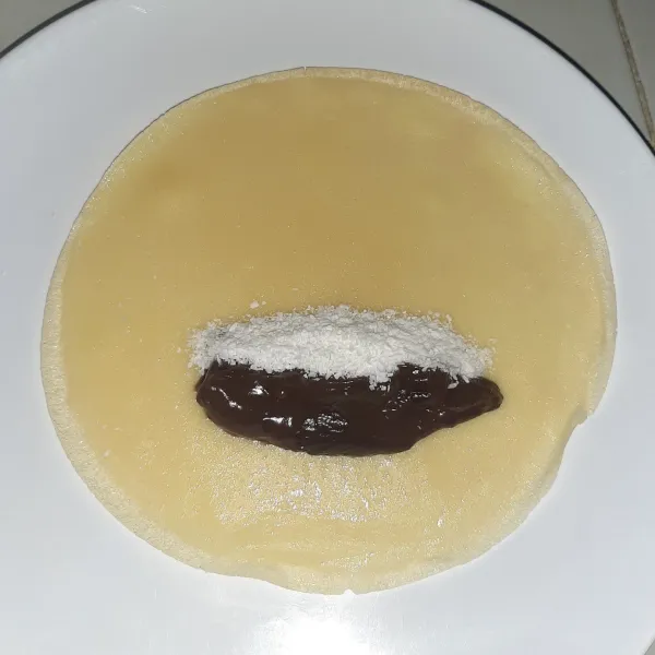 Selagi hangat, segera letakkan isian (vla cokelat dan dessicated coconut).
