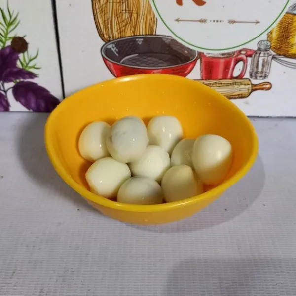 Rebus telur puyuh dan kupas cangkangnya, lalu sisihkan.
