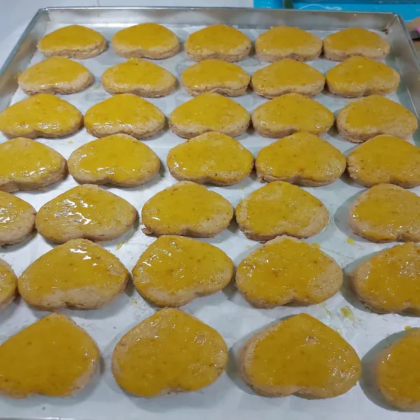 Panaskan oven. Sambil menunggu oven panas, oles rata permukaan kue dengan bahan olesan. Lakukan hingga selesai.