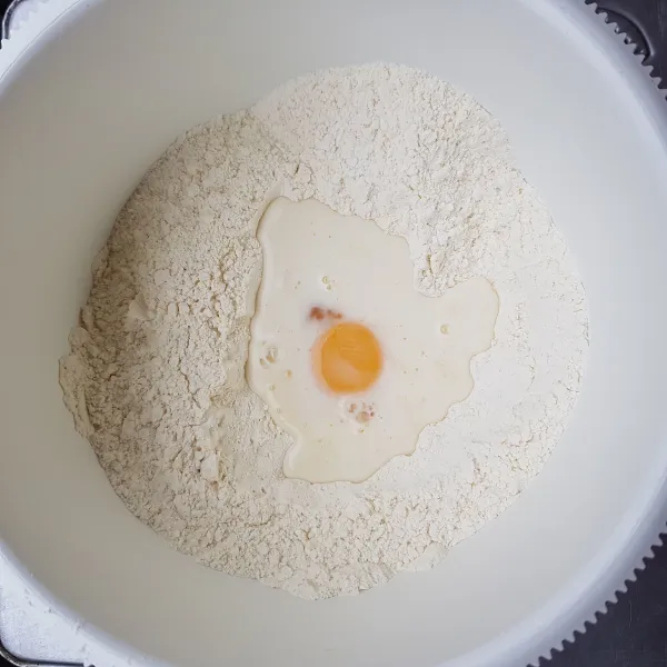 Campur tepung terigu, gula pasir, susu bubuk dan ragi instan, aduk rata. Masukkan campuran telur dan susu di bagian tengah, lalu mixer dengan kecepatan sedang hingga menjadi adonan.