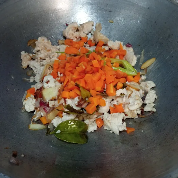 Masukkan ayam giling, masak hingga berubah warna lalu tambahkan wortel dan aduk.