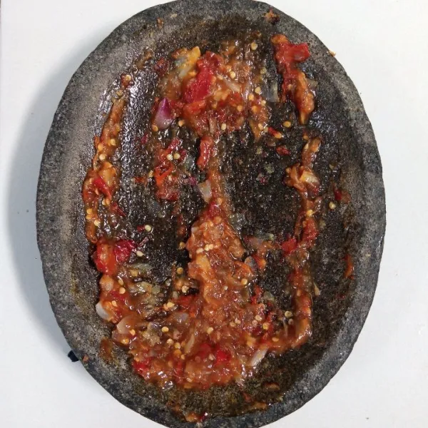 Goreng bawang merah, bawang putih, cabai merah, cabai rawit, dan kencur sampai layu. Kemudian uleg bersama gula pasir dan garam sampai halus.