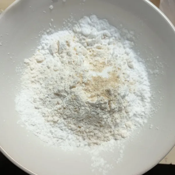 Campur tepung kanji, tepung terigu, garam, kaldu bubuk dan bawang putih bubuk ke dalam mangkok, aduk rata.