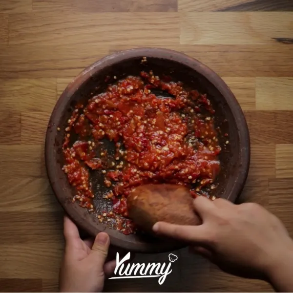 Haluskan cabe merah dan cabe rawit, tomat, terasi, gula, garam dengan cobek. Beri perasan air jeruk nipis. Aduk merata