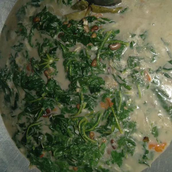 Masukkan daun singkong yang sudah direbus dan di potong sesuai selera. Masak hingga matang dan cicipi rasanya, kemudian angkat dan sajikan.