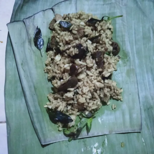 Siapkan 2 lembar daun pisang, tata nasi ati ampela, lalu beri daun kemangi.