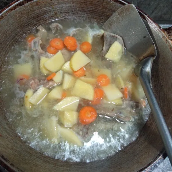 Masukkan kentang dan wortel yang sudah di kupas dan di potong serta bumbui dengan garam, lada bubuk, gula pasir, dan kaldu bubuk. Masak hingga matang.