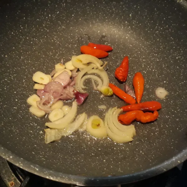 Tumis bawang putih, bawang bombay, dan cabai rawit merah.
