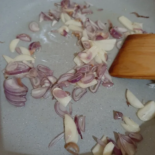 Panaskan minyak goreng. Tumis bawang merah dan bawang putih sampai harum.