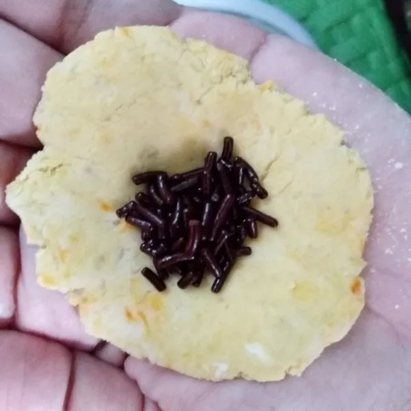 Ambil adonan dengan berat 15 gr dan pipihkan. Lalu beri isian meses, bulatkan lagi.