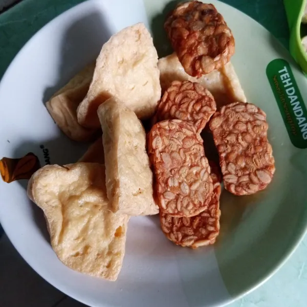 Rendam tahu dan tempe dalam air garam, lalu goreng sampai matang.