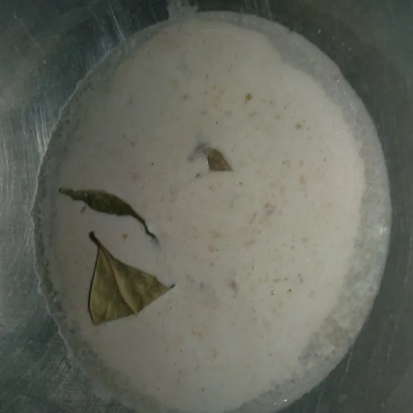 Masukkan santan dalam wajan, daun salam, dan bumbu halus. Lalu didihkan santan.