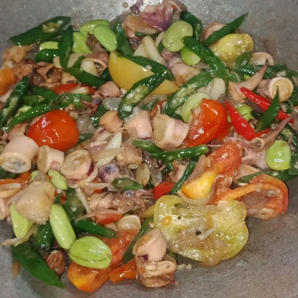 Kemudian tambahkan cumi asin, irisan tomat, air, kecap manis, garam, merica bubuk, dan kaldu bubuk. Aduk rata dan masak hingga air menyusut dan bumbu meresap kemudian tes rasa. Salin cumi ke piring dan sajikan.