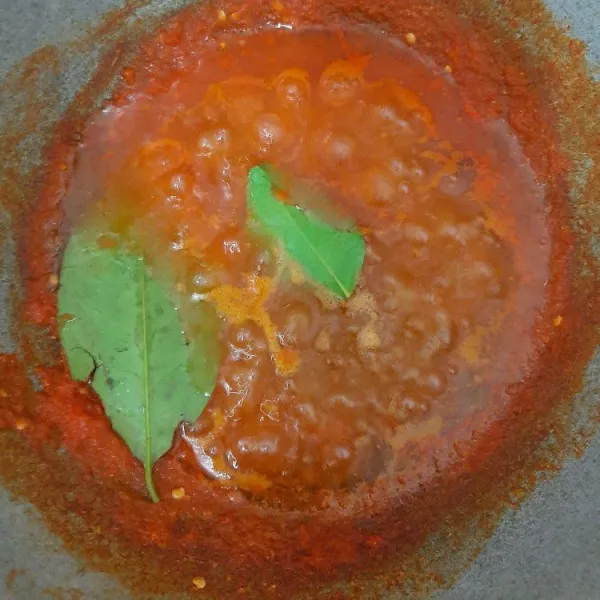 Setelah meresap masukkan minyak goreng, lalu aduk-aduk. Kemudian masukkan daun salam dan daun jeruk.