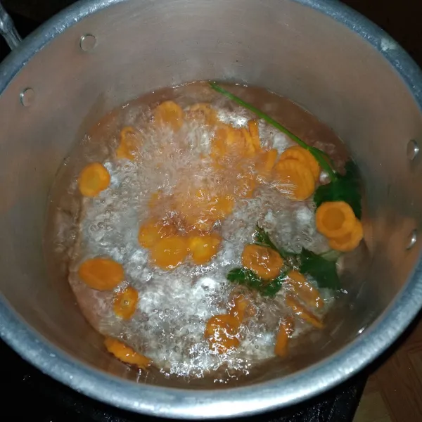 Didihkan air, masukkan daun seledri dan wortel lalu masak selama 10 menit.