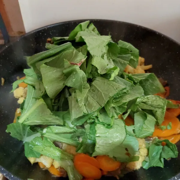 Tambahkan sawi, aduk dan masak sebentar.