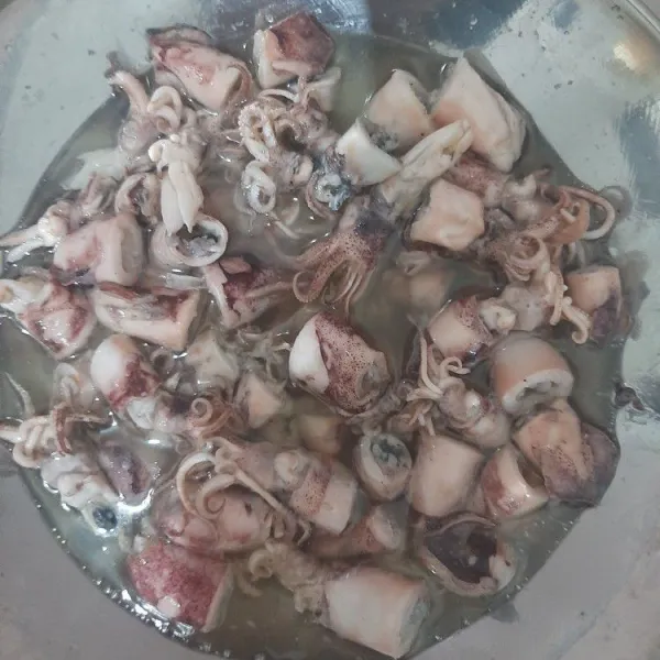 Bersihkan cumi dengan air panas, setelah bersih goreng cumi hingga berubah warna sampai kecokelatan.